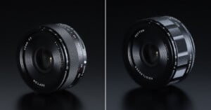 Two camera lenses are displayed side by side on a dark surface; the left lens has a smooth textured ring with red and white markings, while the right lens features a ribbed focus ring and white text around the front element.