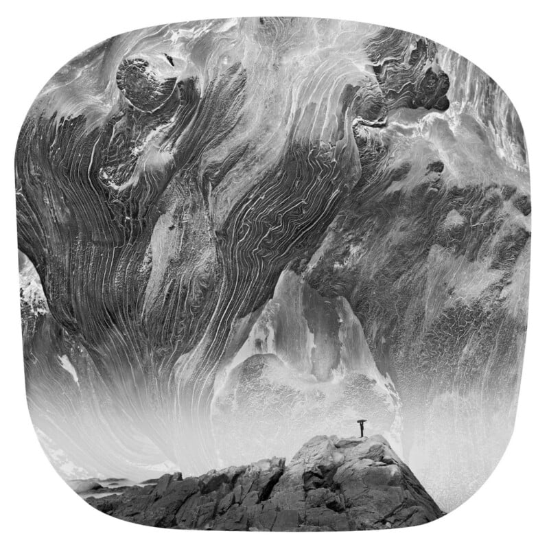 A lone person stands on a rocky peak, looking up at swirling, abstract patterns in the sky resembling marbled clouds, creating a dramatic and surreal scene in black and white.
