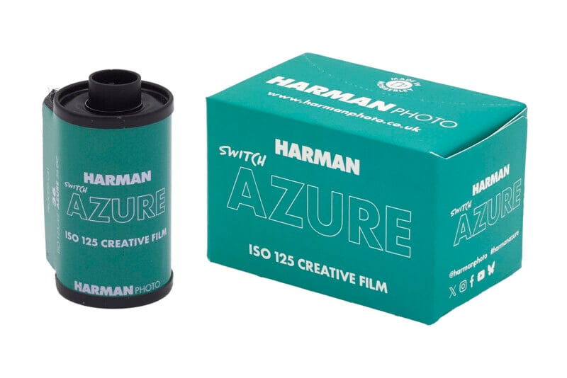 A roll of Harman Azure ISO 125 creative film stands next to its matching turquoise box, both labeled with "HARMAN SWITCH AZURE" and branded with Harman Photo logos and website.