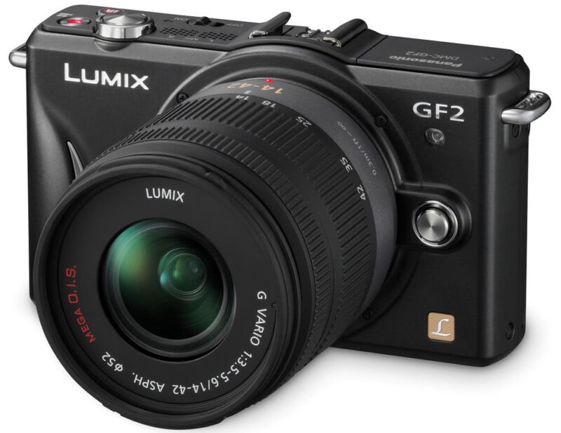 A black Panasonic Lumix GF2 digital camera with a large interchangeable lens, shown angled slightly from the front and side, displaying its brand and model labels clearly.