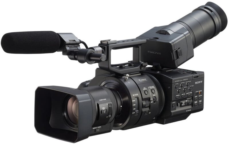 A professional Sony video camera with a large lens, external microphone, and various control buttons, designed for high-quality video recording, displayed on a white background.