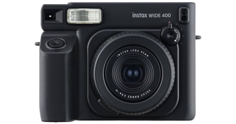 Vista frontal de una cámara instantánea Fujifilm Instax Wide 400 negra, que muestra su lente, flash, visor y perillas de control.