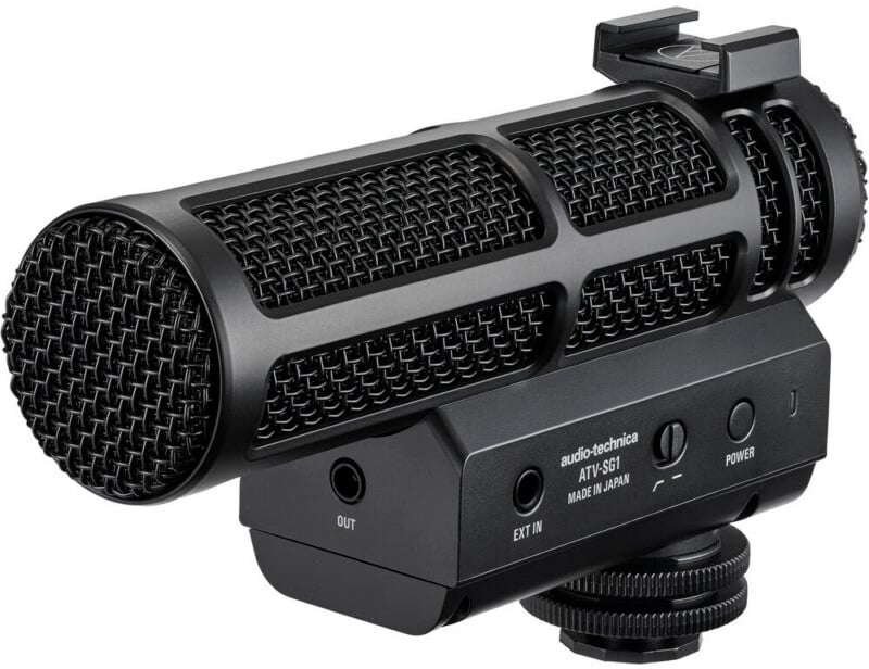 El micrófono negro Audio-Technica ATY-S01 con rejilla metálica, botones de control y soporte de montaje está diseñado para usarse con cámaras o equipos de grabación.