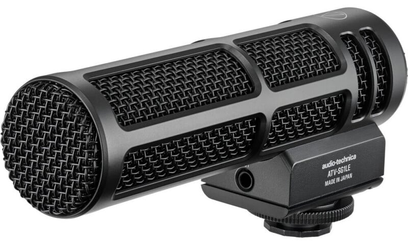 Micrófono de cañón Audio-Technica AT875R negro con rejilla metálica, rejillas de ventilación laterales y soporte de montaje sobre fondo blanco.