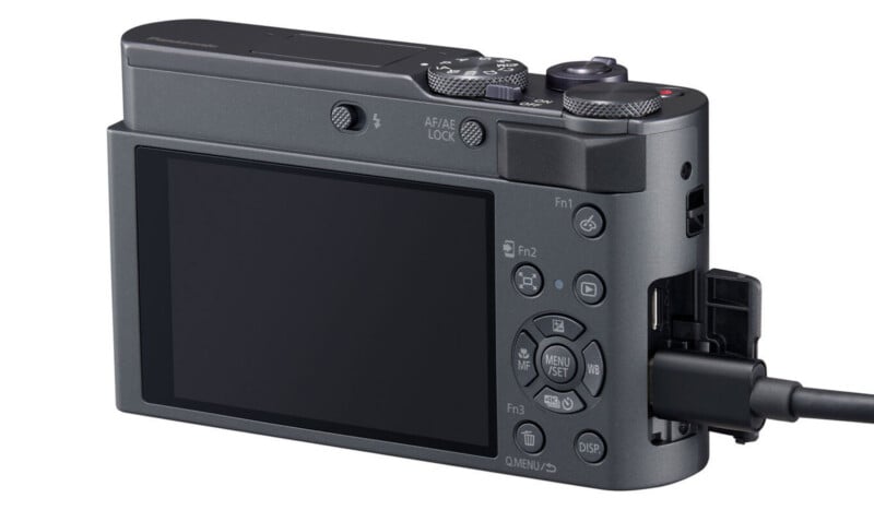 Una vista de primer plano de la parte posterior de una cámara digital, que muestra su pantalla, botones de control y cables conectados a los puertos laterales.