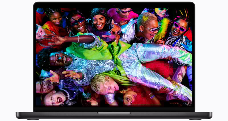 A laptop screen displays a vibrant image of a joyful, diverse group of people at a party, with one person crowd-surfing above others. The scene is colorful, energetic, and festive.