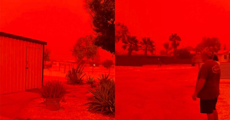 A landscape is bathed in an intense red-orange hue, with buildings, trees, and a person walking outside. The sky appears completely red, likely due to a dust storm or severe atmospheric conditions.