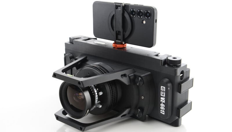 A smartphone mounted on top of a large, professional camera rig with a wide-angle lens, highlighting a setup for advanced photography or videography.