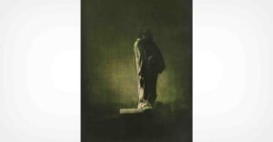A dark, moody image of a stone statue standing on a pedestal, shrouded in shadow and mist, with a somber and mysterious atmosphere.