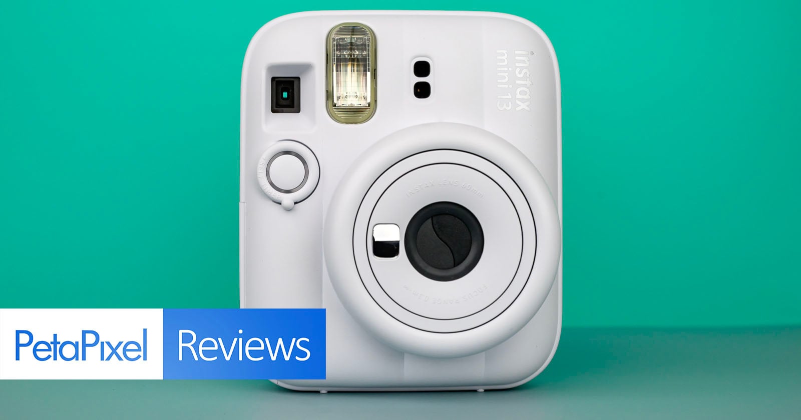 A white Fujifilm Instax Mini 13 instant camera is centered against a teal background. The bottom left features a "PetaPixel Reviews" banner.