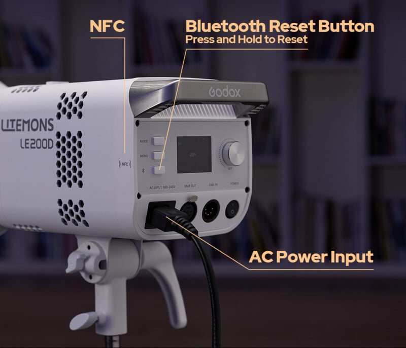 Un primer plano de la parte posterior de la luz de estudio Godox Litemons LE200D, con etiquetas que apuntan al sensor NFC, el botón de reinicio de Bluetooth y la entrada de alimentación de CA, que muestra su panel de control y sus puertos.