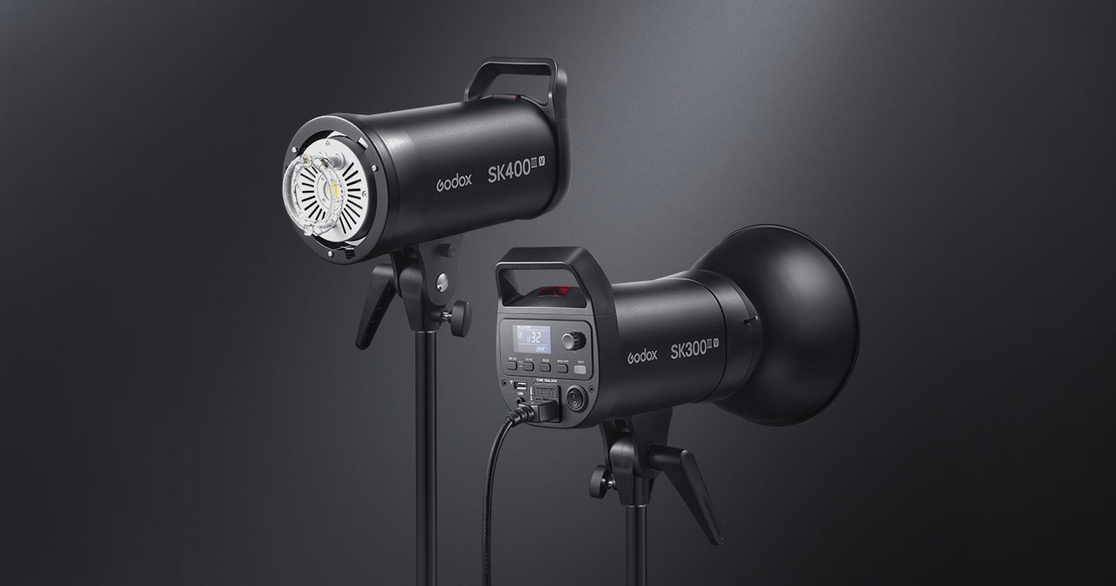 Two black Godox SK400II studio lights on stands; one shows the front with the LED light, the other shows the back with a digital display and control buttons, both against a dark gradient background.
