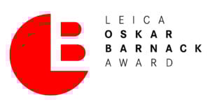 The logo for the Leica Oskar Barnack Award features a large red semi-circle with a white "L" and red "B" inside, alongside the text "LEICA OSKAR BARNACK AWARD" in black, all on a white background.