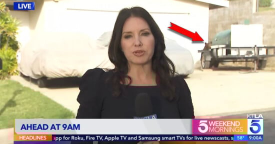 A female news reporter stands outside, speaking into a microphone. Behind her are two covered vehicles and a trailer. A red arrow points to a figure near the covered vehicles. On-screen graphics show news program details.