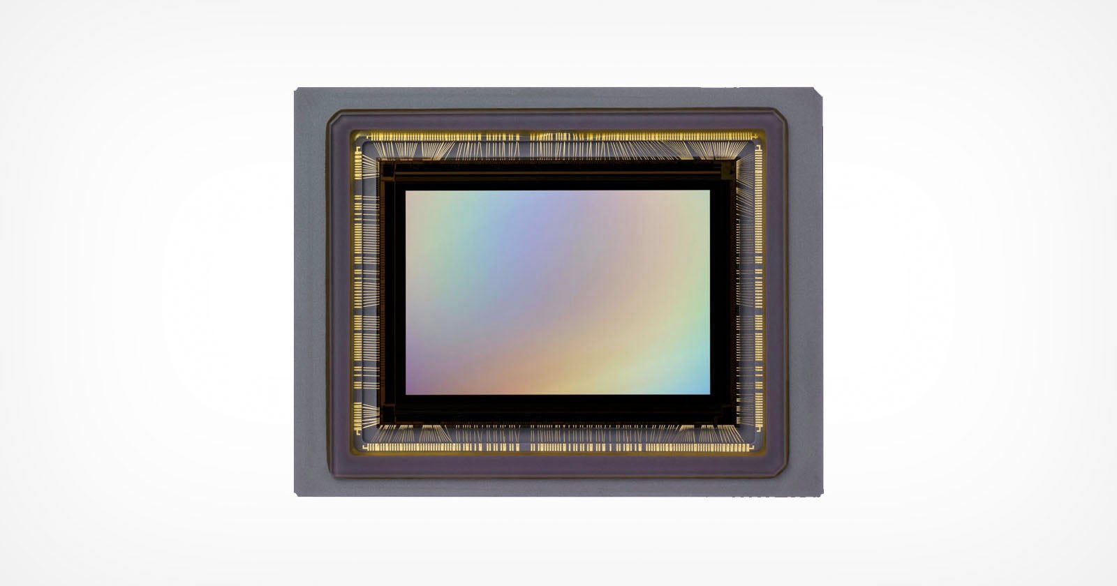 A rectangular camera image sensor with a metallic frame and rainbow-reflective surface, set against a plain white background.