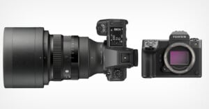 Top view of a Fujifilm digital camera body with its lens detached and positioned beside it, showing the sensor on the camera and dials on both the body and lens, set against a white background.