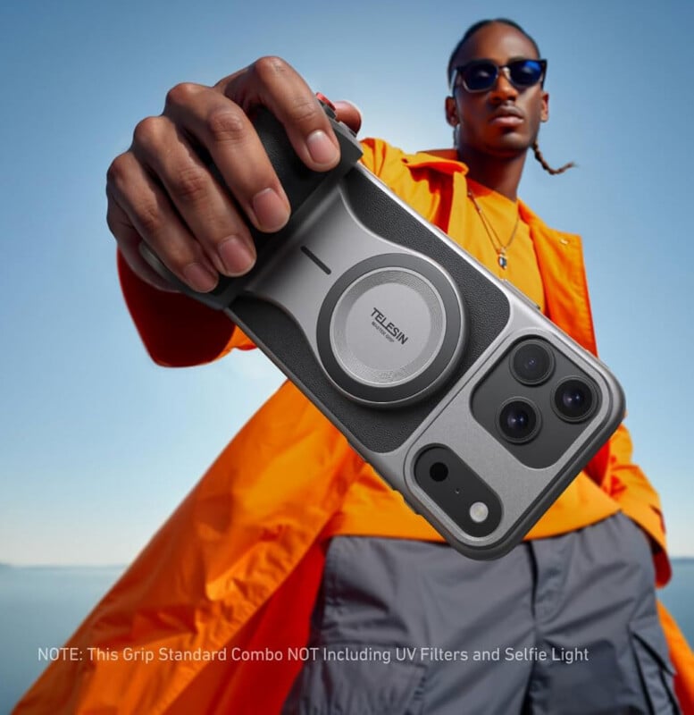 A person in an orange jacket and sunglasses holds a smartphone with a TELESIN camera grip towards the camera. The background is outdoors with a clear blue sky. Text notes that UV filters and selfie light are not included.