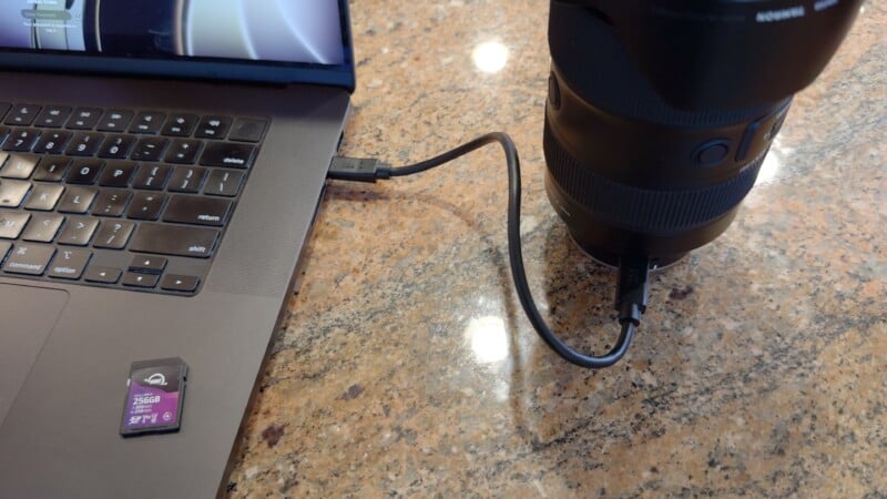 La cámara sobre la encimera de granito está conectada a la computadora portátil mediante un cable USB. La tarjeta de memoria SD se coloca al lado del teclado del portátil.