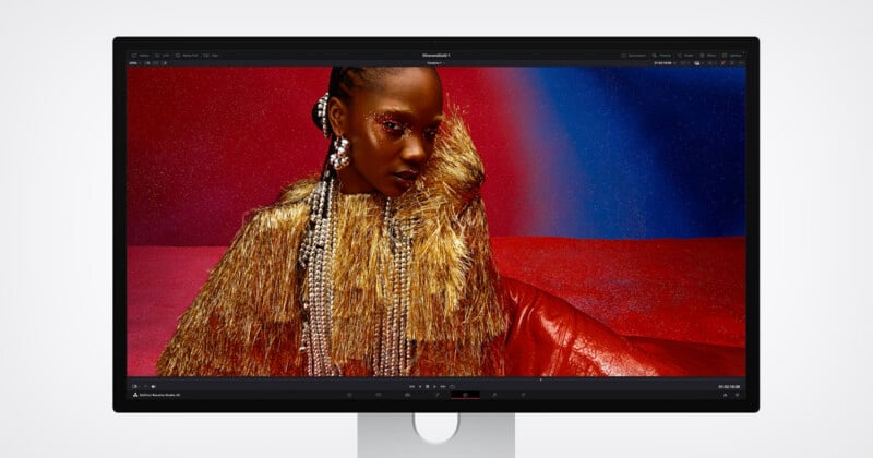 A computer monitor displays a vivid image of a woman wearing gold fringe and sparkling accessories against a red and blue glittery background, showcased in photo editing software.