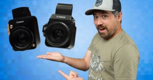 A man in a cap and t-shirt smiles and points at two black Canon cameras floating above his open hand against a blue pixelated background.