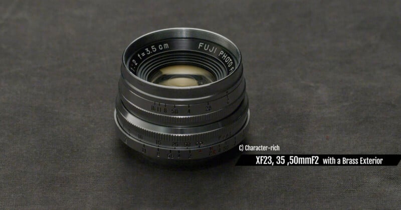 A vintage Fuji Photo camera lens with a brass exterior sits on a dark textured surface. Text on the image highlights it as "XF23, 35, 50mm f2 with a Brass Exterior.