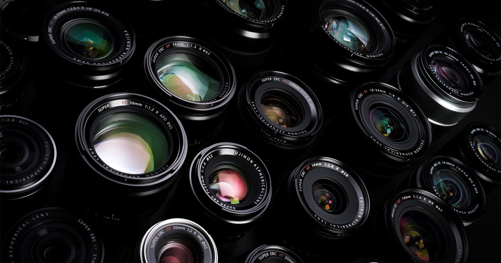 A close-up view of multiple camera lenses arranged closely together, showing their glass elements and reflections, with various brand markings visible on the lens rims.