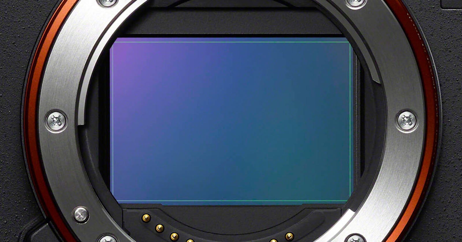 Close-up view of a digital camera's exposed image sensor and lens mount, showing the metallic ring with electronic contacts and the rectangular sensor surface reflecting light.