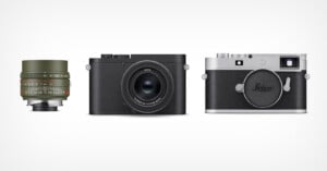 Three Leica camera products on a white background: a green camera lens with red, white, and black markings on the left, a compact black camera in the center, and a silver and black rangefinder camera on the right.