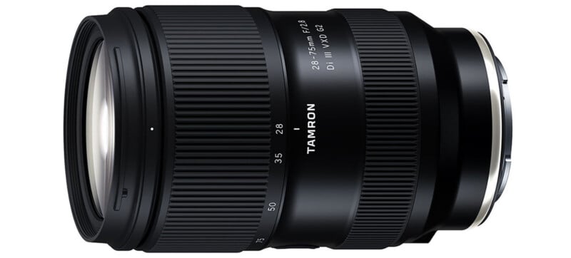 A black Tamron camera lens labeled "28-75mm F/2.8 Di III VXD G2" is shown in a side view, displaying its zoom and focus rings with white markings and text.