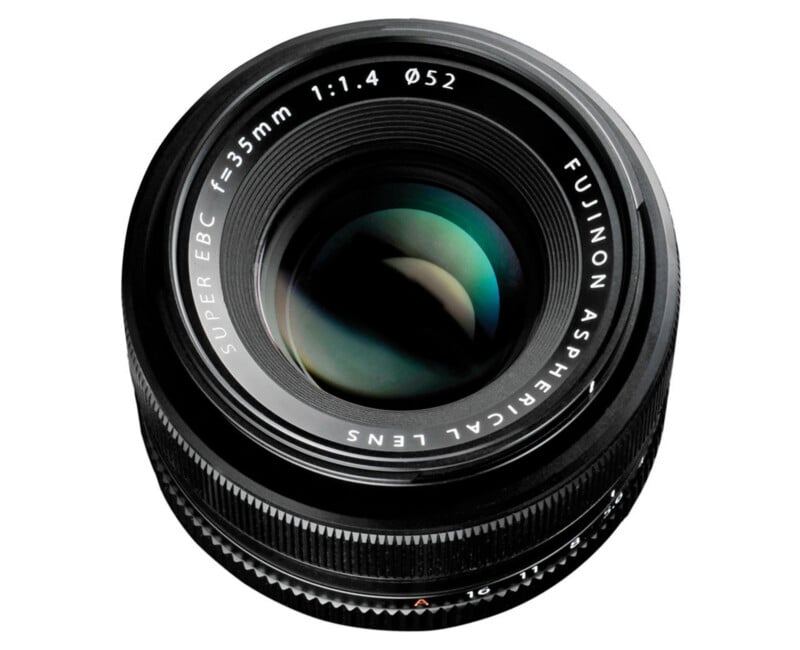 A close-up view of a Fujinon 35mm f/1.4 APS-C camera lens, showing the glass elements and engraved text around the lens barrel.