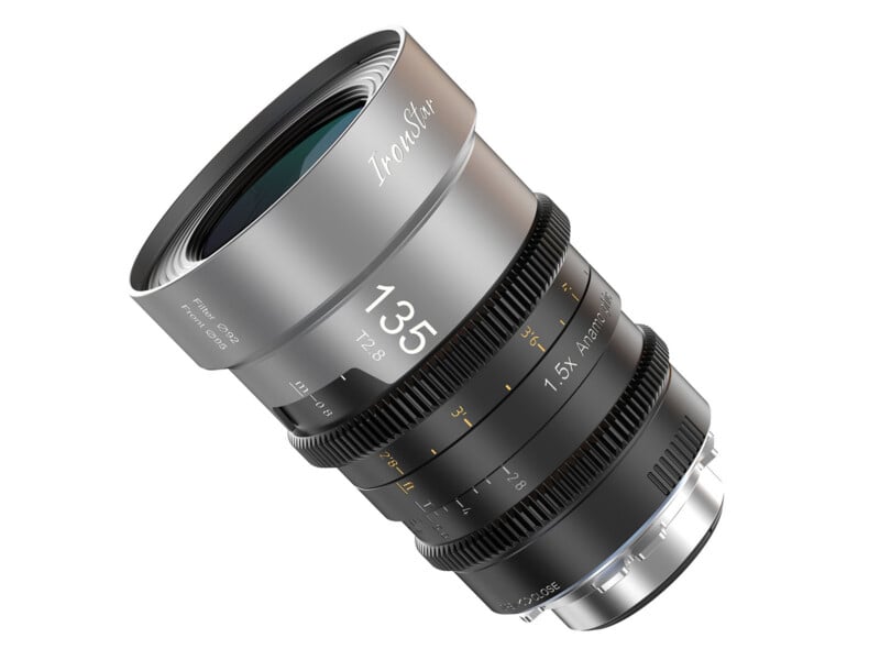 A close-up of a silver IronStar 135mm T2.8 camera lens with gear rings and engraved yellow and white markings, shown at an angle on a white background.