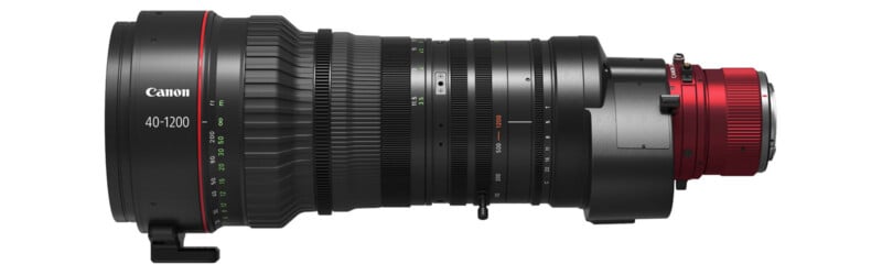 Side view of a Canon 40-1200mm professional broadcast camera lens with a large body, multiple adjustment rings, a tripod mount, and a red lens mount on the right side.