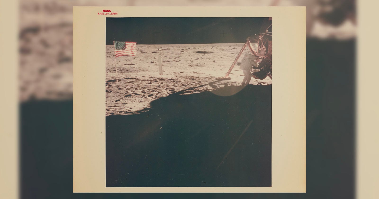 A vintage photo shows the American flag planted on the Moon’s surface, with part of a lunar module visible on the right. The barren, rocky lunar landscape stretches into the background under a black sky.