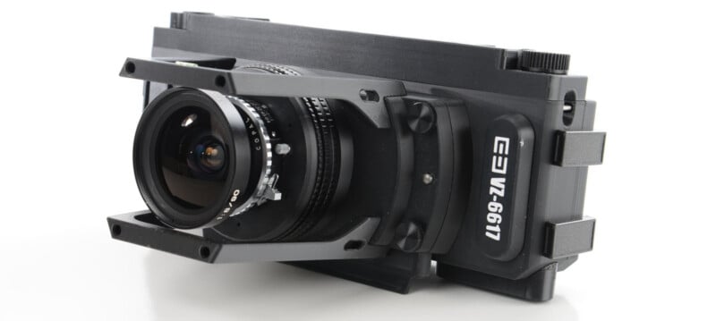A compact black camera with a wide-angle lens and sturdy metal brackets around the lens, featuring the label “EZ VZ-6611” on the side, shown on a white surface.