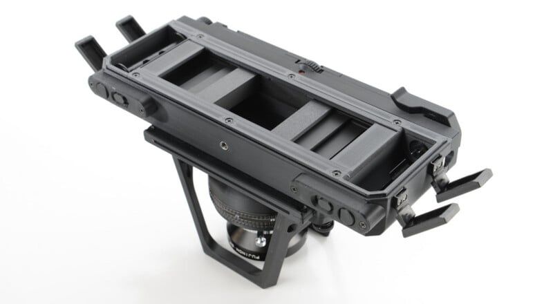 A close-up of a matte box for a camera, featuring a rectangular frame with filter slots, adjustment knobs on the sides, and mounting hardware attached to a camera lens.