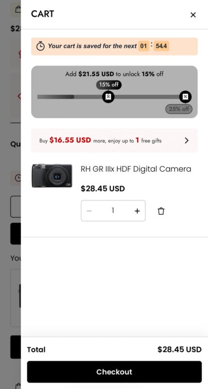 La pantalla del carrito de compras muestra una cámara digital con un precio de $28,45. El banner dice que el carrito se guardó durante 1 minuto y 54 segundos. Las ofertas incluyen un 15 % de descuento cuando gastas $21,55 y un regalo gratis cuando gastas $16,55. El botón de pago está en la parte inferior.