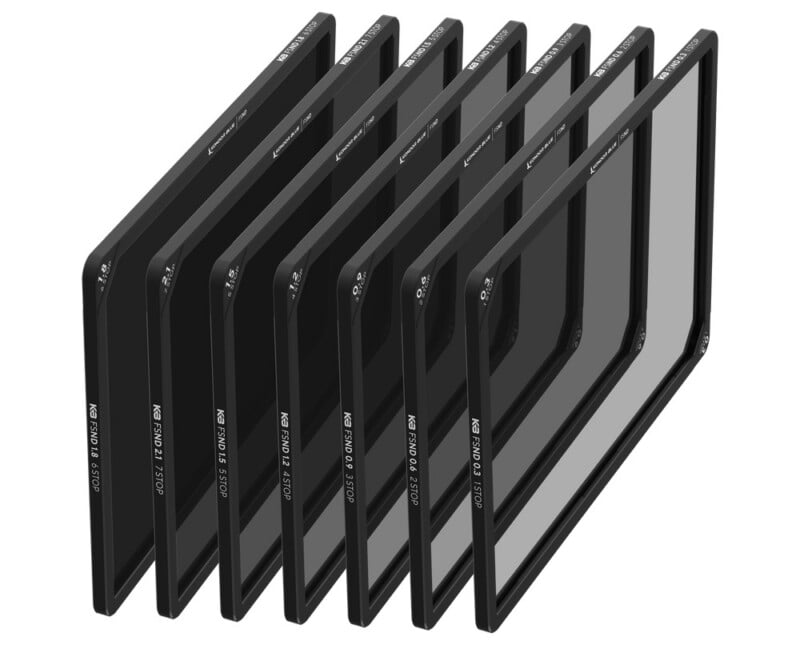 A set of eight rectangular neutral density camera filters, each labeled with different ND strengths, arranged in a row at an angle against a white background.