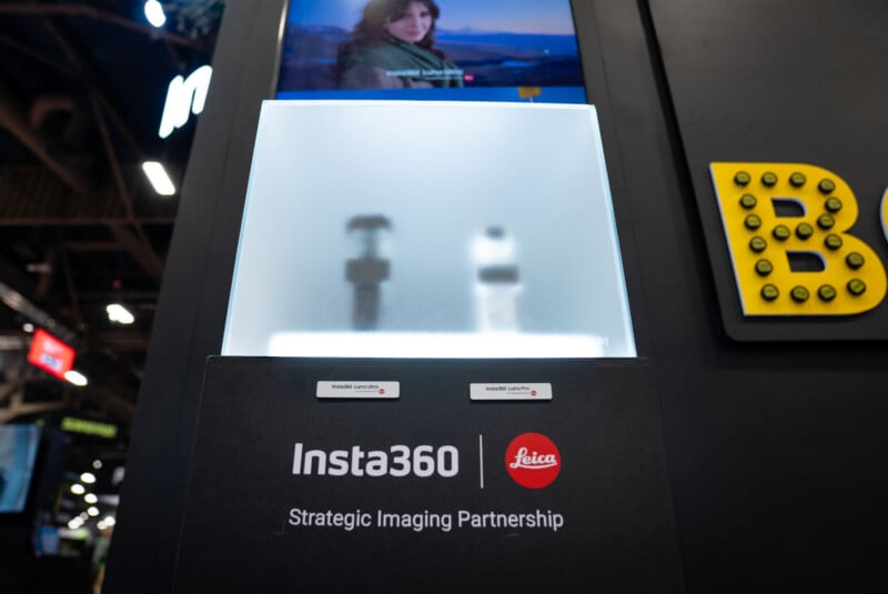 A display at an event shows the Insta360 and Leica logos with the text "Strategic Imaging Partnership." Behind frosted glass, two blurry camera devices are visible. A screen above displays a woman outdoors.