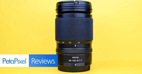 A Nikon Nikkor 24-105mm f/4-7.1 camera lens stands upright against a bright yellow background, with a "PetaPixel Reviews" banner in the lower left corner.