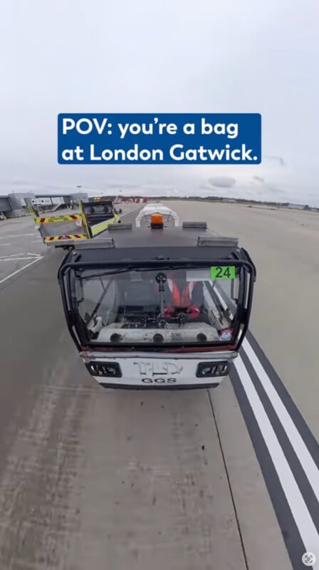 A baggage cart drives down a runway at London Gatwick Airport, as seen from above. Text overlay reads: "POV: you’re a bag at London Gatwick." Other airport vehicles and equipment are visible in the background.