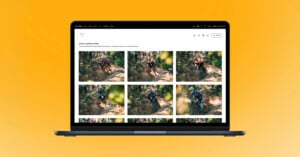 A laptop displays a photo gallery of mountain bikers riding on a rugged forest trail, set against a bright orange background.
