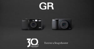 Two Ricoh GR cameras are displayed side by side on a black background, with "GR" above them and "30th Anniversary - Forever a Snapshooter" written below in white text.
