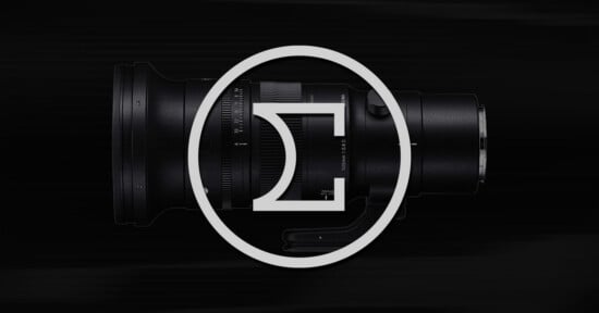 A black camera lens is positioned horizontally on a dark background, with a large white Sigma logo superimposed over the center of the image.