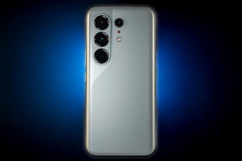 A silver smartphone with three large camera lenses and two smaller sensors on the back, displayed upright against a dark blue gradient background. The brand name "TECNO CAMON" is visible near the bottom.