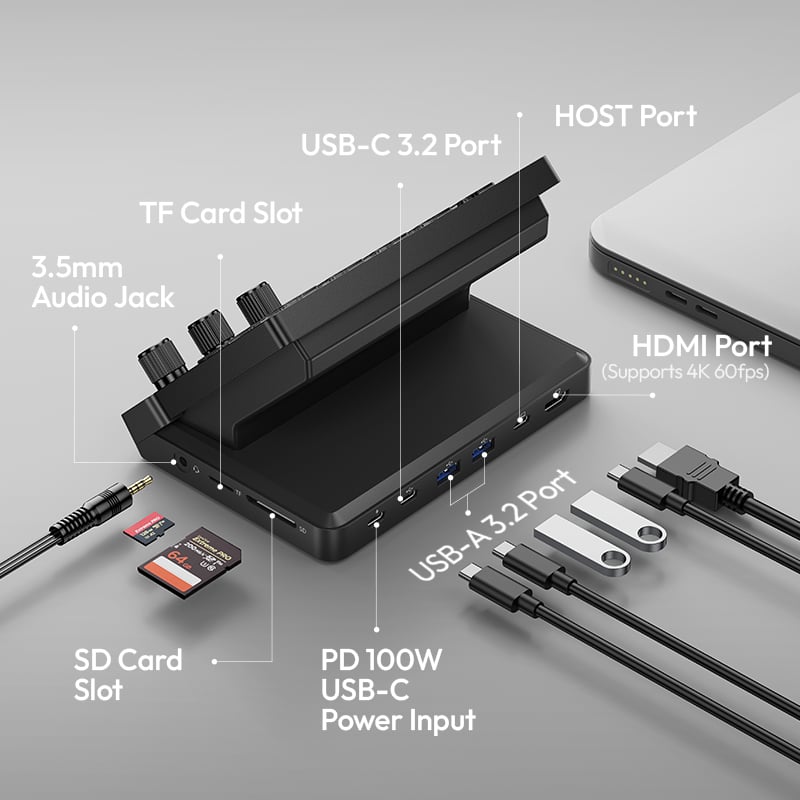 A black multi-port docking station connected to a laptop, featuring labeled ports: USB-C 3.2, HOST, HDMI, 3.5mm audio, USB-A 3.2, SD/TF card slots, and a PD 100W USB-C power input. Various cables and cards are shown.
