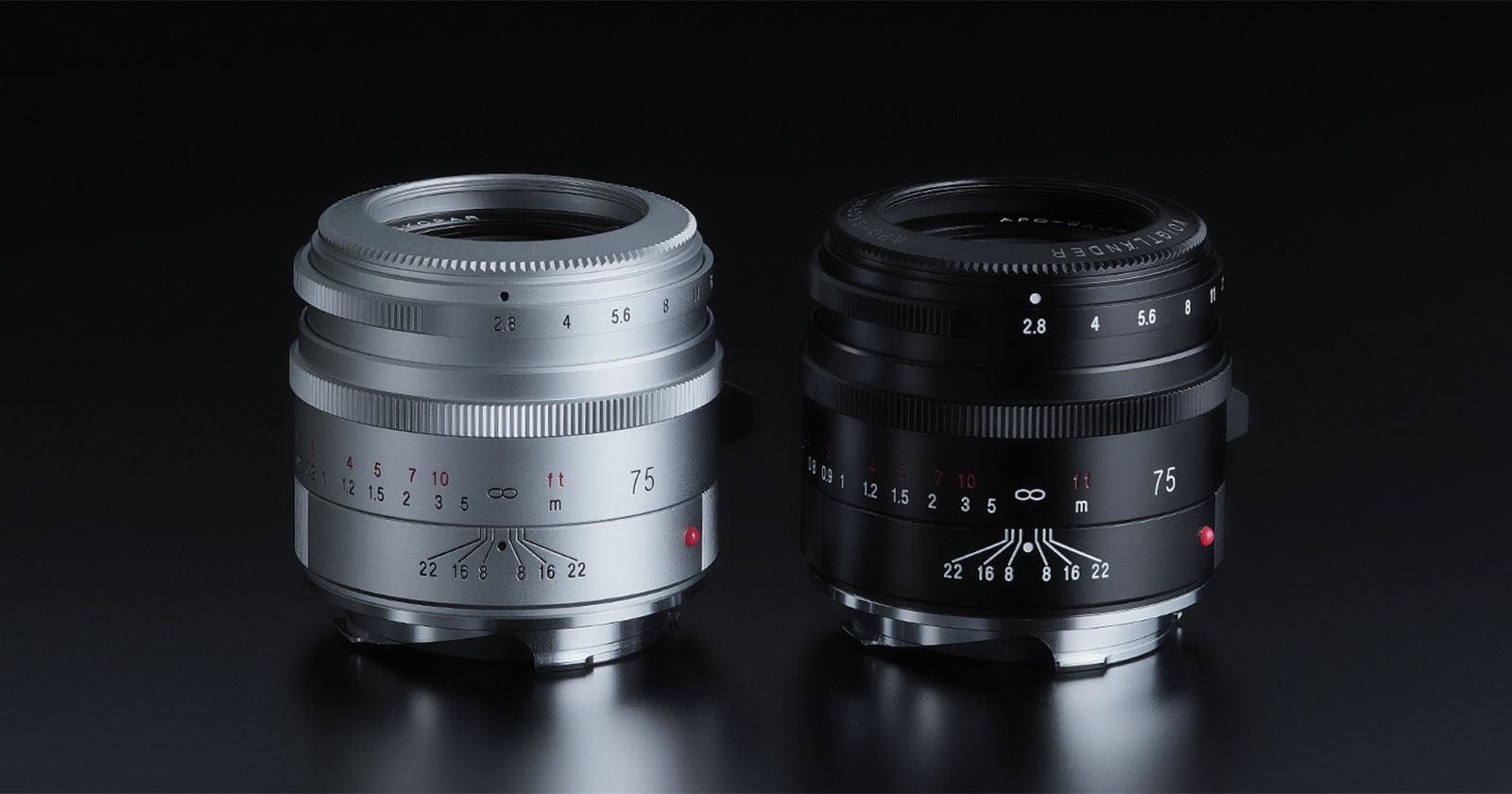 Two camera lenses are displayed side by side on a black surface, one in silver and one in black. Both lenses have similar designs, with aperture and focus markings and the number “75” visible on the front.