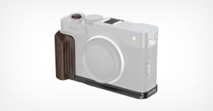 A translucent camera body displaying a dark wooden grip and a black metal baseplate attachment on the left and bottom sides of the camera.
