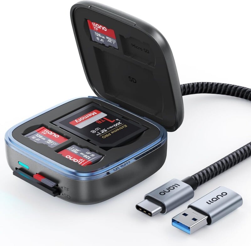 A black and gray memory card reader with an open lid displays multiple inserted SD and microSD cards. A detachable USB-C to USB-A cable labeled "llano" is placed beside the device.