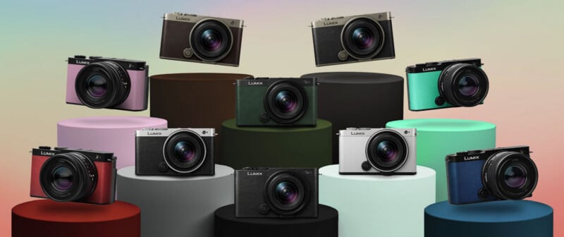 Ten Lumix cameras in various colors are displayed on and above cylindrical platforms of different heights and shades, set against a pastel gradient background.