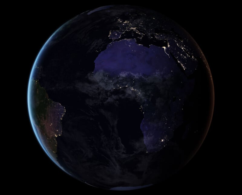 A view of Earth from space at night, showing city lights across Africa and parts of Europe, with the surrounding areas in darkness and the edge of South America visible on the left.